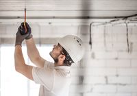 electrician-installer-with-tool-his-hands-working-with-cable-construction-site