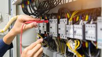 electricians-hands-testing-current-electric-control-panel